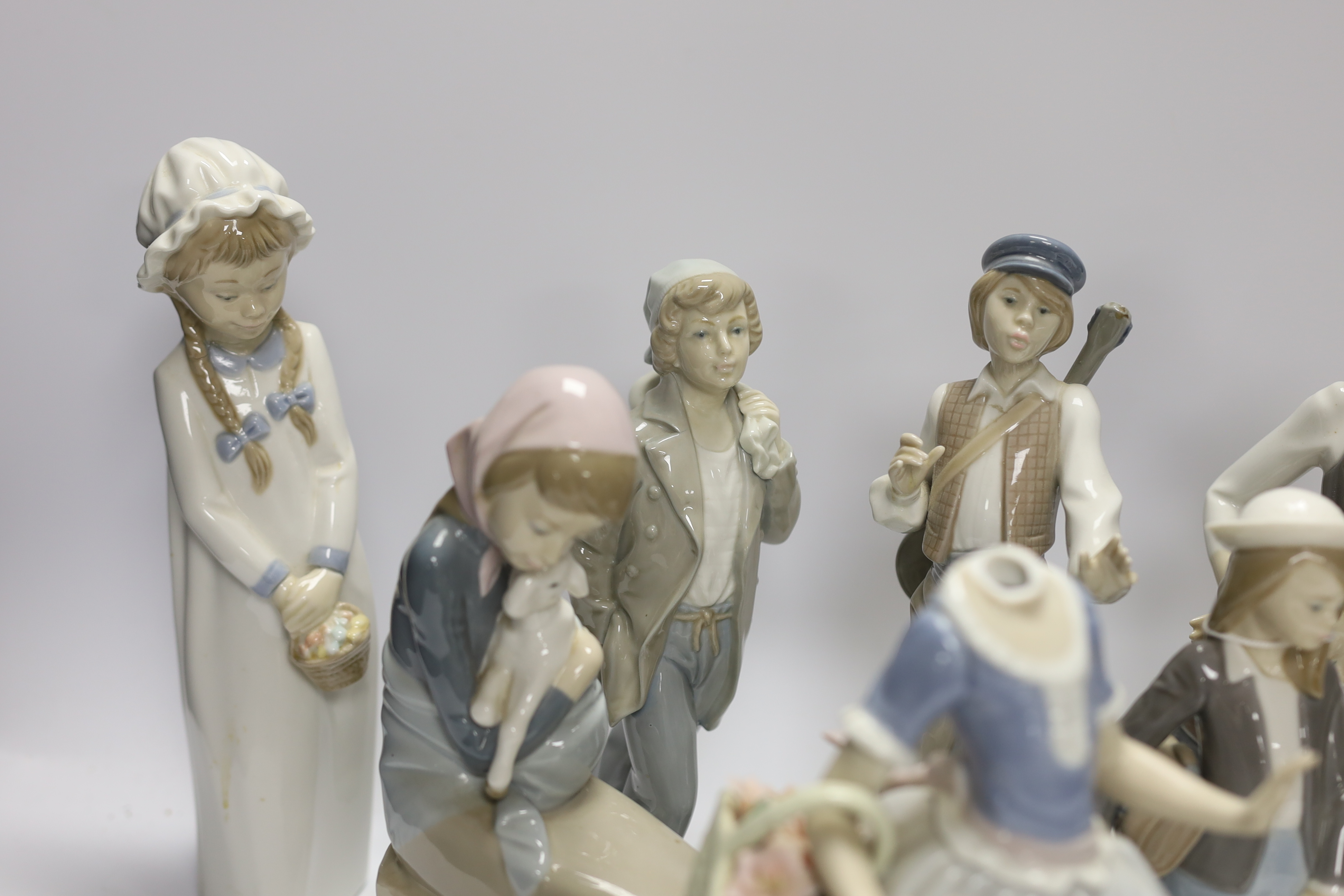 Ten Lladro and Nao figures including a short eared owl and a girl with braids, largest 26cm high